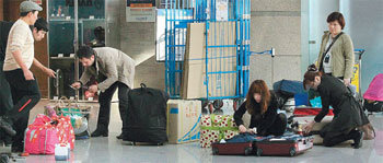 공항에서 짐정리하는 승객들