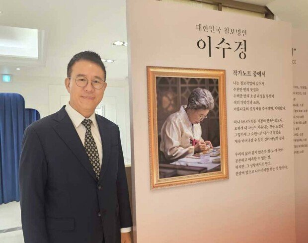 Kim stands in front of a photograph of his mother, Master artisan Soo-kyung Lee