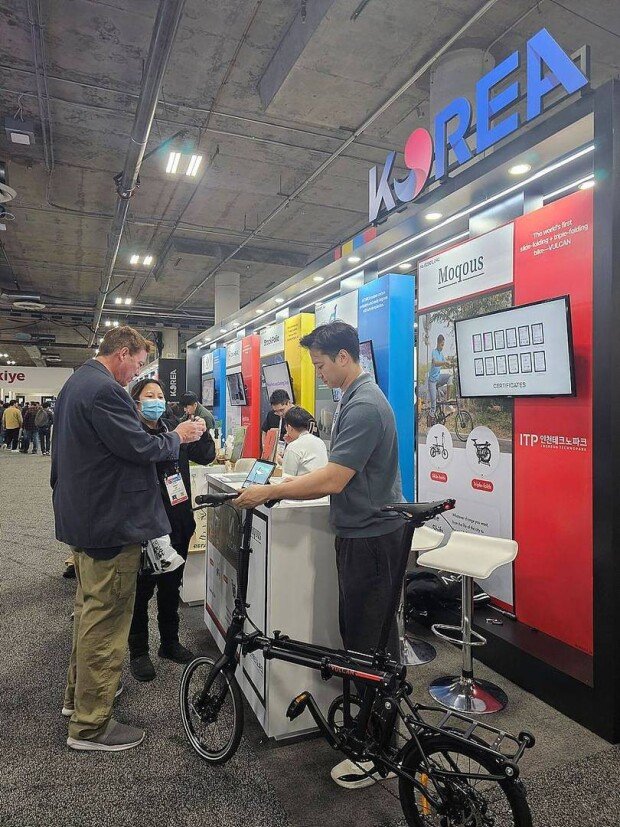 CEO Bok-yong Hong (rightmost) who introduces the pop cycle at the fair / source = Moqous