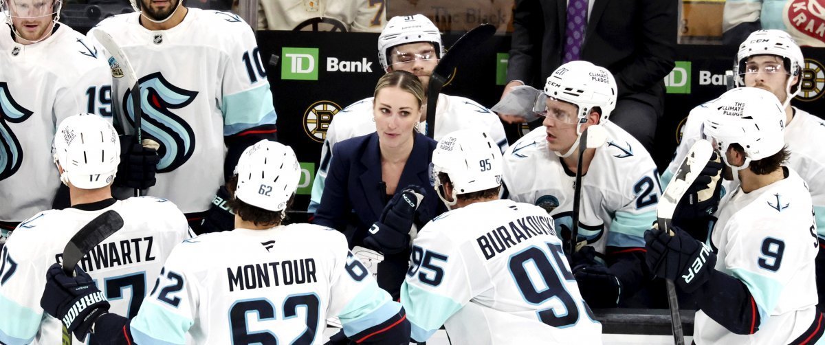 選手たちに囲まれたNHL初の女性コーチ、タイムアウトに指示する 