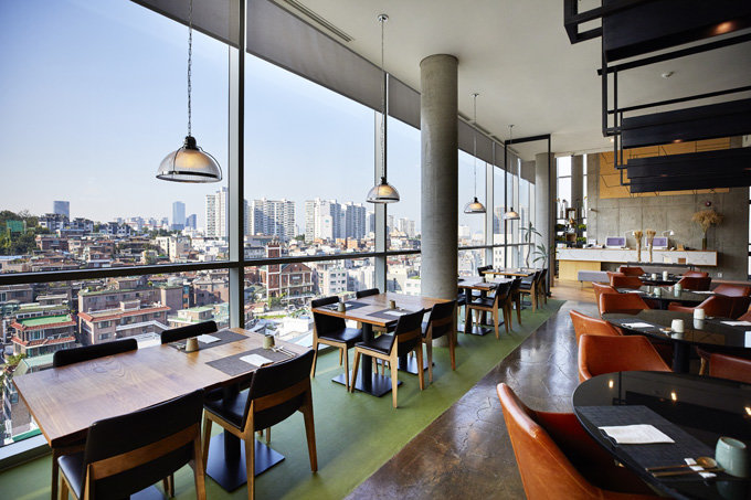 9층 로비에 위치한 한식 레스토랑 ‘나루’의 통유리로 내려다보이는 상도동 주택가 풍경. 1950~2000년대까지 한국 주택 건축양식이 파노라마처렴 펼쳐진다.