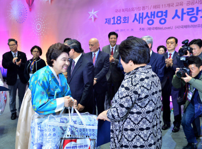 장길자 국제위러브유운동본부 회장이 국내 지원 대상 가족에게 기금 증서와 이불을 선물하며 따뜻한 위로와 격려를 하고 있다. [박해윤 기자]