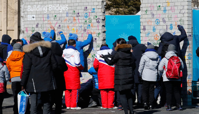 2월 5일 평창선수촌에서 열린 평창올림픽 휴전벽 제막식에서 원길우 북한 선수단장을 비롯한 선수단이 서명하고 있다.