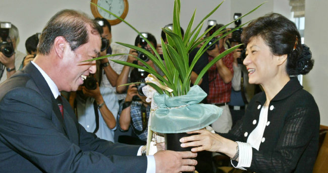 2004년 7월 20일 당시 김병준 대통령비서실정책실장이 박근혜 신임 한나라당 대표에게 노무현 대통령의 축하난을 전하고 있다. [서영수 동아일보 기자]