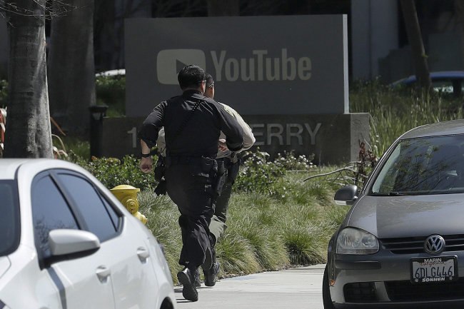 4월 3일 오후 미국 캘리포니아주 샌브루노 유튜브 본사에서 발생한 권총 총격 사건 현장으로 경찰들이 뛰어가고 있다. 이 사건으로 3명이 총상을 입었으며 용의자는 범행 후 권총으로 자살했다. [샌브루노=AP 뉴시스]