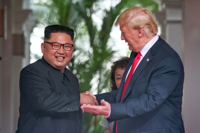 6월 12일 트럼프 대통령이 미소를 지으면서 김정은 위원장과 악수하고 있다. 
