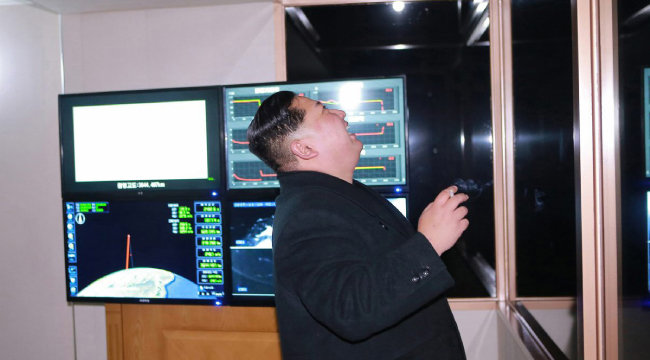 김정은 북한 국무위원장이 2017년 10월 29일 평안남도 평성에서 담배를 든 채 대룩간탄도미사일 시험발사 장면을 지켜보면서 활짝 웃고 있다. [동아DB]