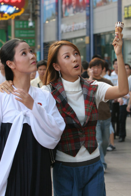 가수 이효리(오른쪽) 씨와 북한 무용수 조명애 씨가 2005년 9월 12일 중국 상하이에서 아이스크림을 먹으며 길거리를 구경하고 있다. [동아DB]