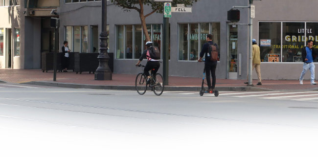 샌프란시스코 마켓스트리트 자전거도로에서 한 청년이 공유스쿠터를 타고 이동하고 있다.