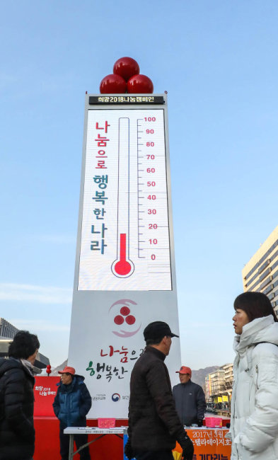 2017년 12월 서울 세종대로 광화문광장에서 시민들이 ‘사랑의 온도탑’ 앞을 지나고 있다. [뉴스1]