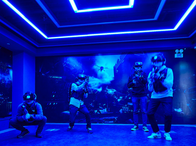 도심형 복합 VR 테마파크 브라이트에서 VR 전투게임을 즐기는 사람들.
