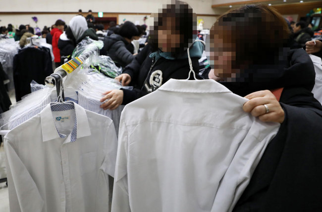 2019년 2월 14일 서울 성동구 성동구청 대강당에서 열린 '사랑의 교복 나눔장터'에서 학부모들이 교복을 고르고 있다. [뉴시스]