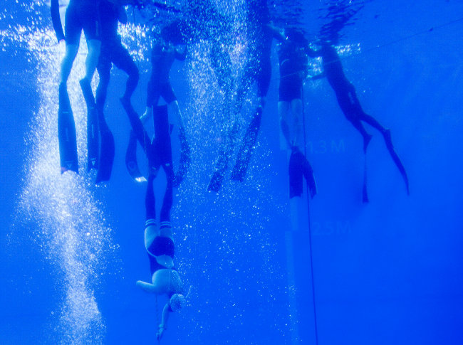 잠수풀에서 프리다이빙을 즐기는 사람들 
