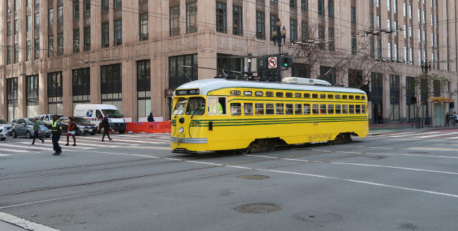 자가용 운행이 금지된 샌프란시스코 마켓스트리트를 ‘도시의 명물’ 전차가 달리는 모습. 마켓스트리트와 연결된 도로에서 오는 자가용이 진입하지 못하도록 형광색 조끼를 입은 도시교통국 직원이 통제하고 있다. 