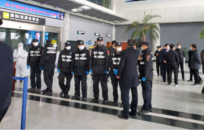 2월 25일 중국 산둥성 웨이하이국제공항에서 경찰과 공항 관계자들이 한국발 입국자를 이송하기 위해 대기하고 있다. [뉴시스]