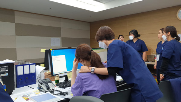 육체 및 정신적 피로로 힘겨워하는 자원봉사 간호사를 격려하는 수간호사의 모습. 