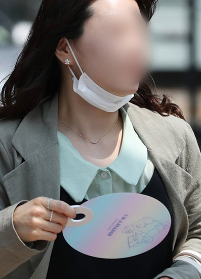 14일 오후 서울 종로구 광화문 인근에서 마스크를 내린 한 시민이 부채질을 하며 발걸음을 재촉하고 있다. [뉴스1]
