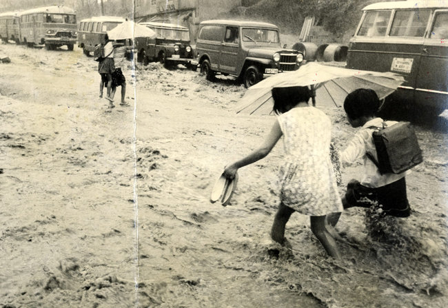 1964년 9월 물에 잠긴 서울 시내를 우산 쓴 아이들이 지나고 있다. [동아DB]