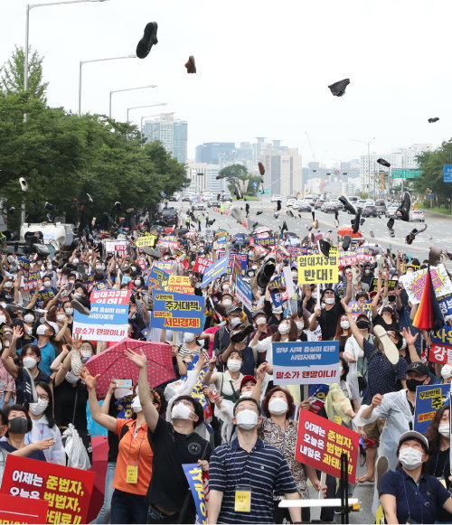 8월 1일 서울 여의도에서 열린 ‘전 국민 조세 저항 집회’에서 참석자들이 신발을 하늘로 던지는 퍼포먼스를 하며 정부의 부동산 정책을 규탄하고 있다. [동아DB]