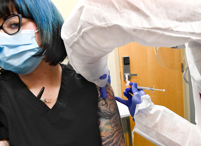 7월 27일(현지시간) 미국 뉴욕에서 제약사 모더나의 코로나19 백신 임상시험에 참여한 여성이 백신 후보물질을 투여받고 있다. [뉴시스]