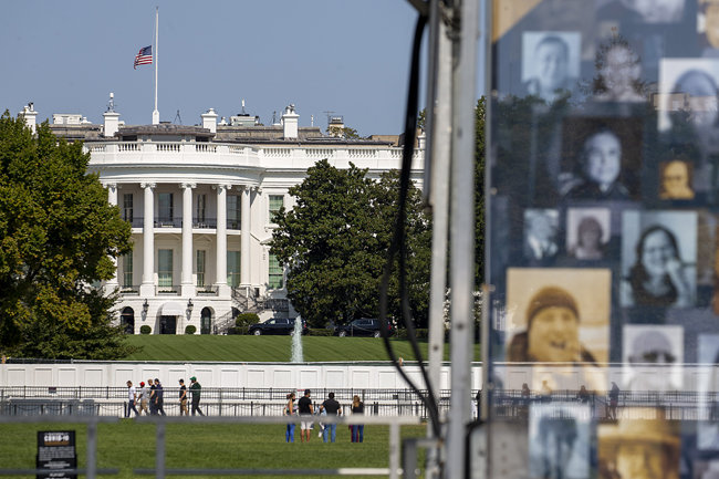 일립스 공원에 걸린 코로나19 사망자 사진 뒤로 백악관이 보인다.  [GettyImage]