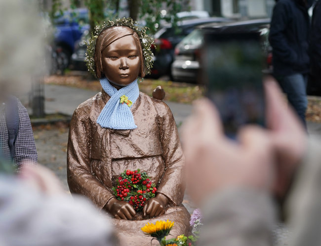 소녀상이 베를린 시민들이 선물한 목도리와 화관, 꽃다발로 장식돼 있다. [GettyImage]