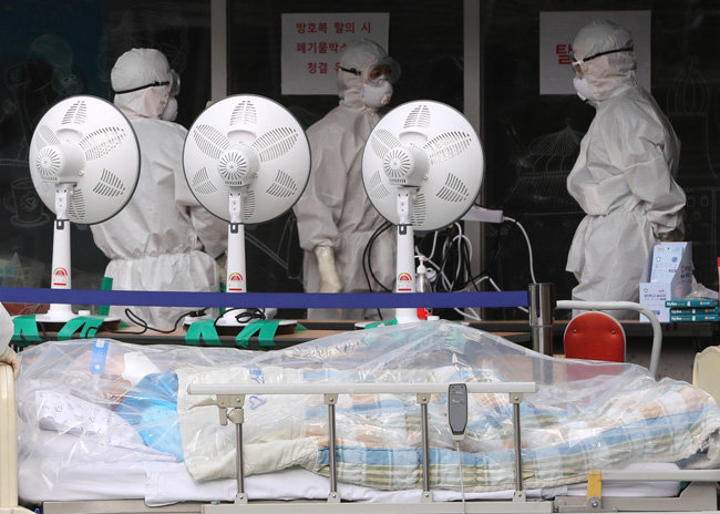 정부가 코로나19 집단 감염이 발생한 서울 구로구 미소들요양병원에 남아있던 확진자를 전원하기로 발표한 지난해 12월 31일 오후, 해당 병원에서 방호복을 입은 관계자들이 환자를 이송하고 있다. [뉴스1]
