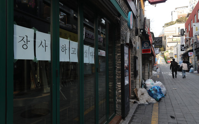 1월 14일 서울 용산구 이태원 거리에서 코로나19 타격으로 사실상 폐업절차를 밟고 있는 한 가게에 ‘장사하고 싶다’는 글귀가 붙어 있다. [홍진환 동아일보 기자]
