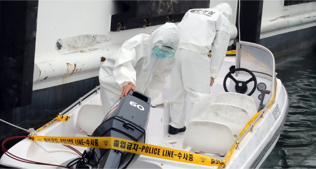 해양경찰청 관계자들이 지난해 5월 25일 충남 태안군 신진항 해경 전용 부두에서 중국인 6명이 밀입국에 사용한 것으로 추정되는 소형 보트를 감식하고 있다. [뉴스1]