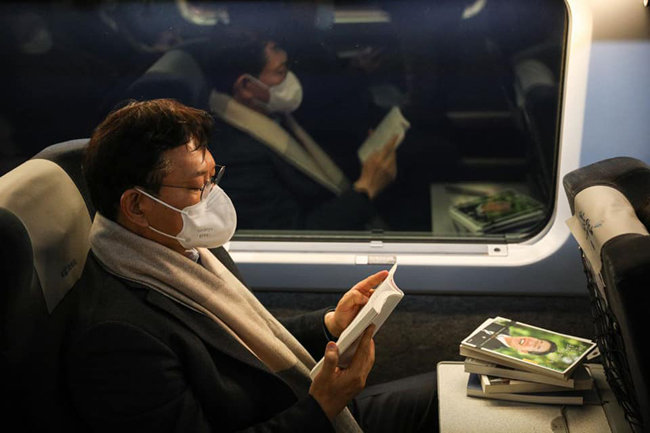 송영길 더불어민주당 대표가 울산으로 가는 기차 안에서 ‘이재명은 합니다’ 책을 읽고 있는 모습.[송영길 페이스북] 