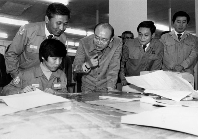 1983년 10월 29일 삼성전자 부천 공장을 방문해 직접 직원들과 이야기하는 전두환(가운데) 당시 대통령. 이건희 회장(오른쪽에서 두 번째)과 김광호 반도체사업본부장(왼쪽 서 있는 인물)도 함께 있다. [동아DB]