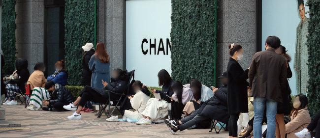 지난해 11월 가격인상을 앞두고 서울 중구 신세계백화점 본점 샤넬 매장 오픈 전부터 시민들이 입장하기 위해 줄을 서거나 앉아 기다리고 있다. [뉴스1]