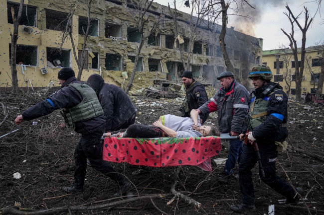 3월 9일 우크라이나 마리우폴에서 산부인과 병원이 러시아군의 포격을 받아 응급 구조요원과 자원봉사자들이 부상한 임신부를 옮기고 있다. [뉴시스]