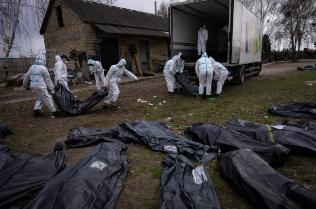 4월 12일 우크라이나 부차에서 자원봉사자들이 러시아군이 살해한 민간인들의 시신을 트럭에 싣고 있다. [AP/뉴시스]