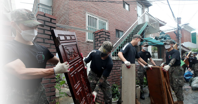 8월 11일 서울 동작구 상도동 성대전통시장에서 육군 장병들이 폭우로 피해를 본 집기를 밖으로 내놓고 있다. 장병들이 입은 상의가 육군 여름 운동복이다. [동아DB]