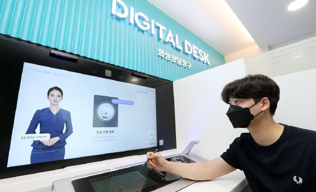 6월 고객이 서울의 한 시중은행 지점에서 AI 은행원을 통해 업무를 보고 있다. AI 은행원은 마인즈랩의 기술이다. [동아DB]