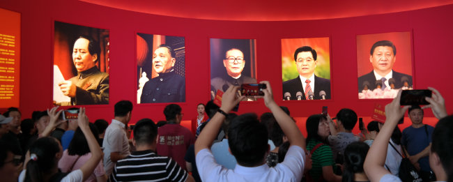 2019년 9월 24일 중국 정부 수립 70주년(10월 1일) 기념 특별전을 보러 베이징전람관을 찾은 중국인들이 중국 공산당의 역대 최고지도자들의 사진이 걸린 전시 공간에 몰려들어 사진을 찍고 있다. 왼쪽부터 마오쩌둥, 덩샤오핑, 장쩌민, 후진타오, 시진핑 현 중국 국가 주석. [동아DB]