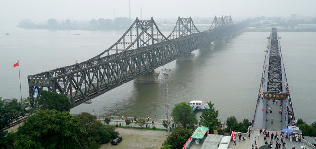 중국 단둥 세관을 통과한 화물 차량 행렬이 압록강 대교를 이용해 북한 신의주로 들어서고 있다. [뉴시스]