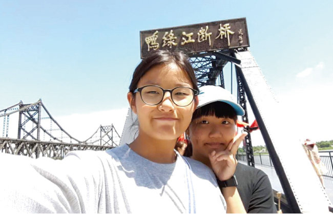 2016년 여름 중국 단둥철교 앞에서 성주 씨(왼쪽)와 영주 씨가 사진을 찍고 있다. [김형덕]