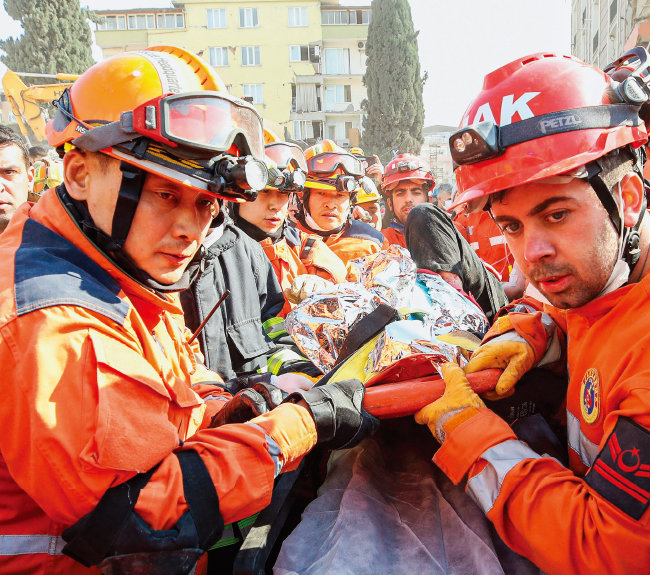 2월 11일(현지 시간) 튀르키예 하타이주 안타키아 일대에서 한국긴급구호대(KDRT)와 튀르키예 구조대가 지진으로 무너진 건물 속 60대 생존자를 구조해 앰뷸런스로 옮기고 있다. [뉴시스]