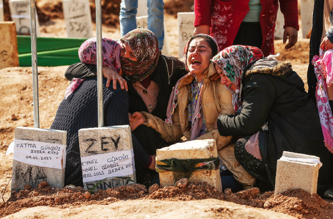 2월 10일 튀르키예 아디야만에 마련된 지진 피해자들의 묘지. 사랑하는 이를 잃은 사람들이 부둥켜안고 오열하고 있다. [뉴시스]