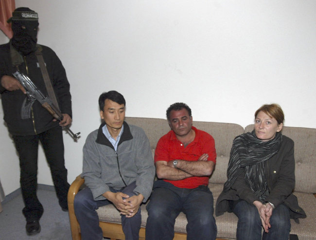 2006년 3월 14일 팔레스타인인민해방전선(PFLP)의 무장조직에 의해 가자지구 칸 유니스 난민캠프에 잡혀 있는 당시 KBS 용태영 특파원(왼쪽)과 통신사 SIPA의 사진기자 알프레드 야코브자데 씨(가운데), 프랑스 주간지 엘르의 특파원 카롤린 로랑 씨. [gettyimages]