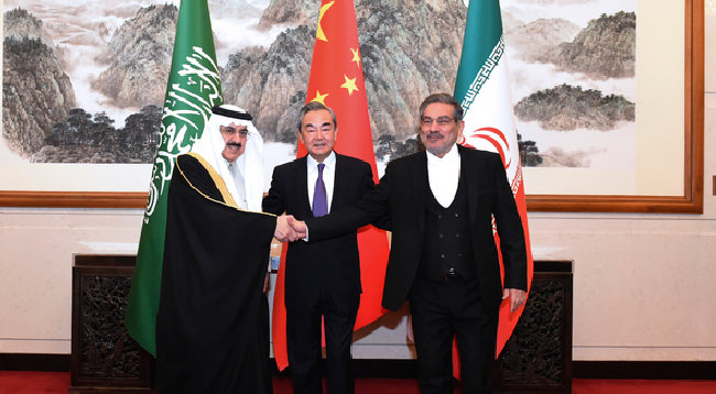 3월 10일 중국 베이징에서 무사드 빈 모하메드 알아이반 사우디아라비아 국가안보보좌관(왼쪽)과 알리 샴카니 이란 국가안보회의 의장(오른쪽)이 중국 외교 사령탑인 왕이 공산당 중앙정치국 위원을 가운데 두고 악수하고 있다. [AP뉴시스]