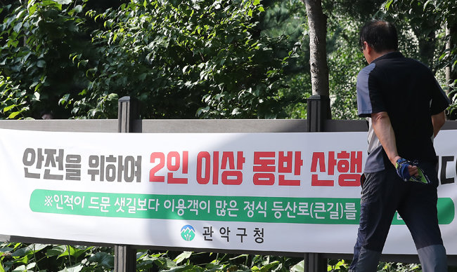 서울 관악구 신림동 공원 강간 살인 사건이 발생한 관악산 생태공원 인근에 2인 이상 동반 산행을 권고하는 구청의 현수막이 걸려 있다. [뉴스1]