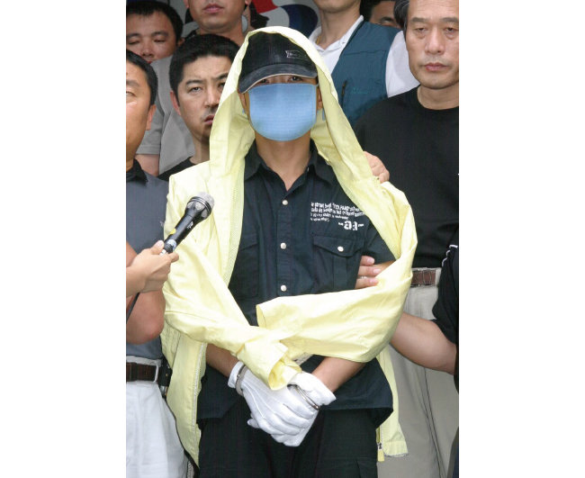 2004년 7월 18일 연쇄살인 혐의로 검거된 유영철이 현장검증에 나서기 전 서울 마포구 서울경찰청 기동수사대에서 기자들의 질문을 받고 있다. 그는 “혐의를 인정하느냐”는 질문에 고개를 끄덕였다. [동아DB]
