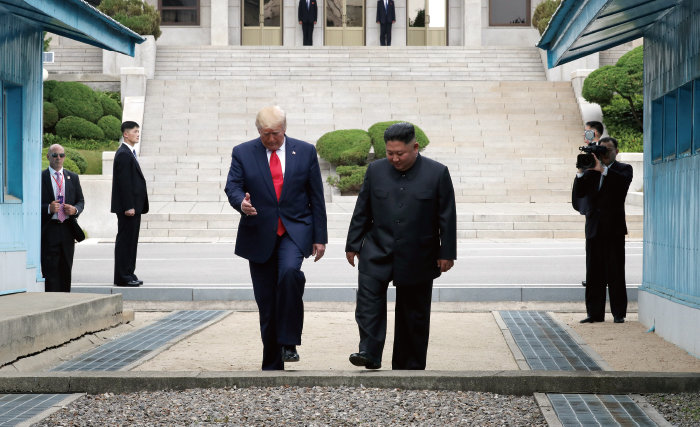 2019년 6월 30일 도널드 트럼프 당시 미국 대통령이 판문점에서 김정은 북한 노동당 총비서와 만나 인사한 뒤 군사분계선을 넘어 북측으로 갔다가 다시 김 위원장과 함께 남측으로 넘어오고 있다. [청와대사진기자단]