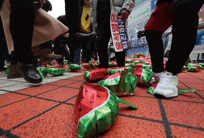 3월 3일 서울 영등포구 여의도동 더불어민주당 당사 앞에서 이재명 대표 지지자들이 수박 풍선을 밟아 터뜨리는 퍼포먼스를 벌이고 있다. [뉴시스]
