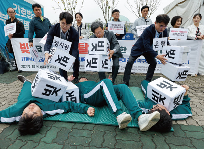 지난해 10월 19일 서울 여의도 국회 앞에서 중소상인·금융소비자단체 회원들이 정부에 가계부채 대책 마련을 촉구하는 퍼포먼스를 하고 있다. [동아DB]