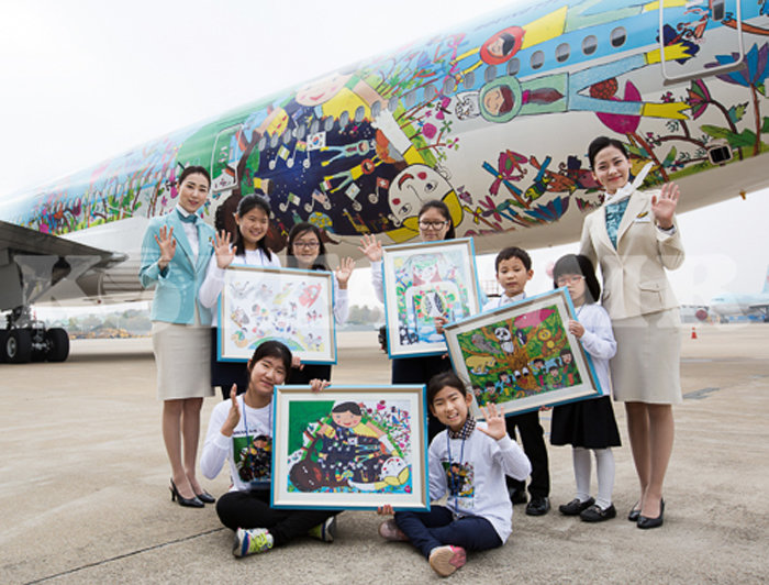 ‘내가 그린 예쁜 비행기’ 사생대회에 참가한 초등생들이 완성된 그림과 함께 기념사진을 찍고 있다.
