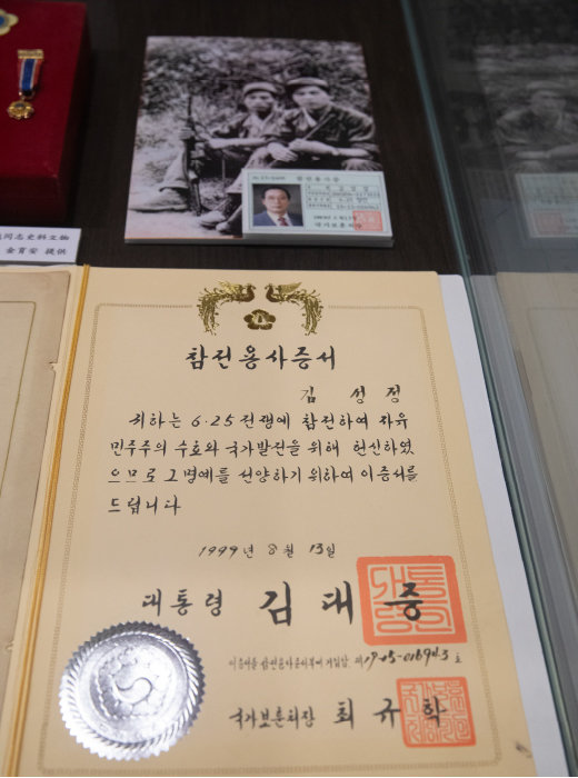 박물관에 전시된 김성정 씨의 참전용사증서와 참전 당시 촬영한 사진. [지호영 기자]